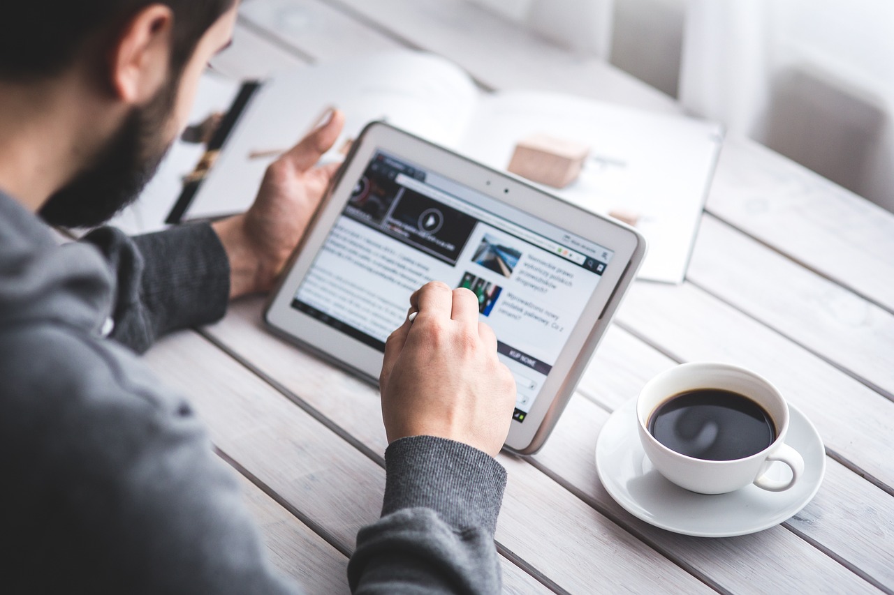 man looking at blog posts on laptop