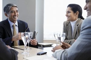 businessmen and women talking around a table