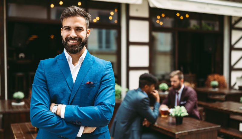 man standing outside a business smiling